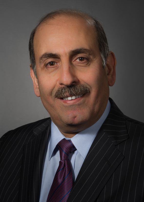 Souhel Najjar, MD, wearing a striped suit, blue shirt and red and blue tie